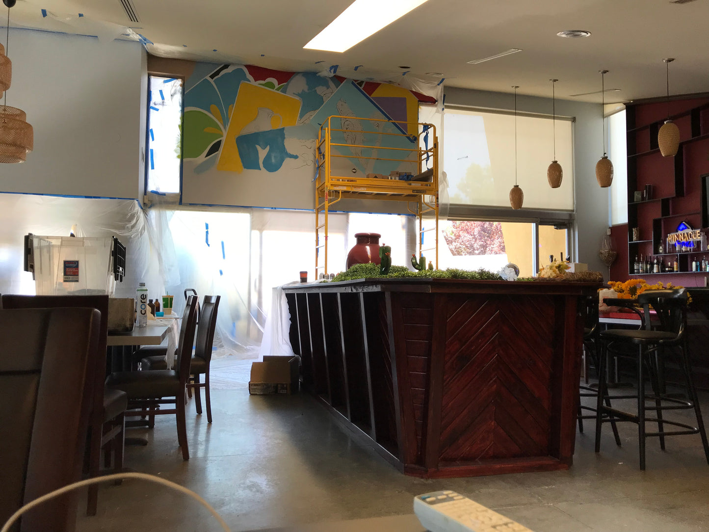 Modern interior of a restaurant with a colorful mural on the wall.