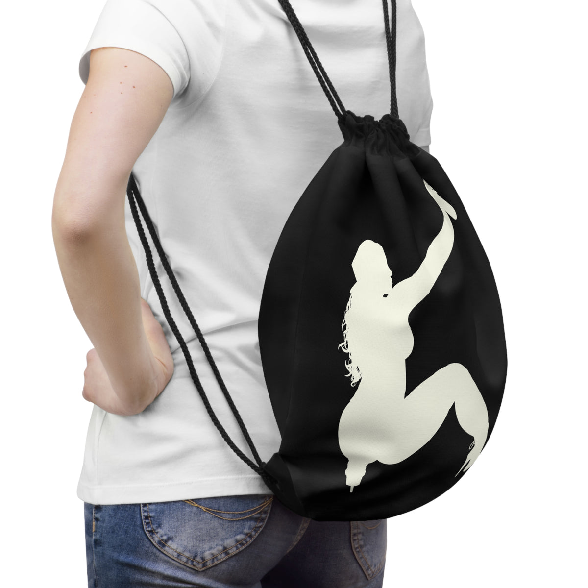 A person wearing a white t-shirt and blue jeans is shown from the back, carrying a black drawstring backpack with a large cream-colored silhouette graphic of a kneeling figure on the back.