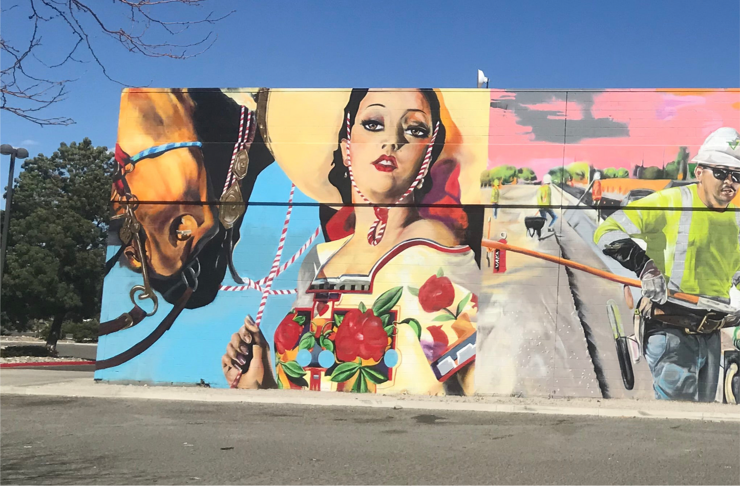 Mural on a wall featuring a woman, horse, and construction worker with a colorful background.