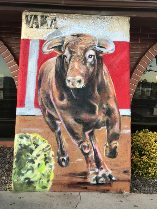 Painting of a bull on a wall with a red background