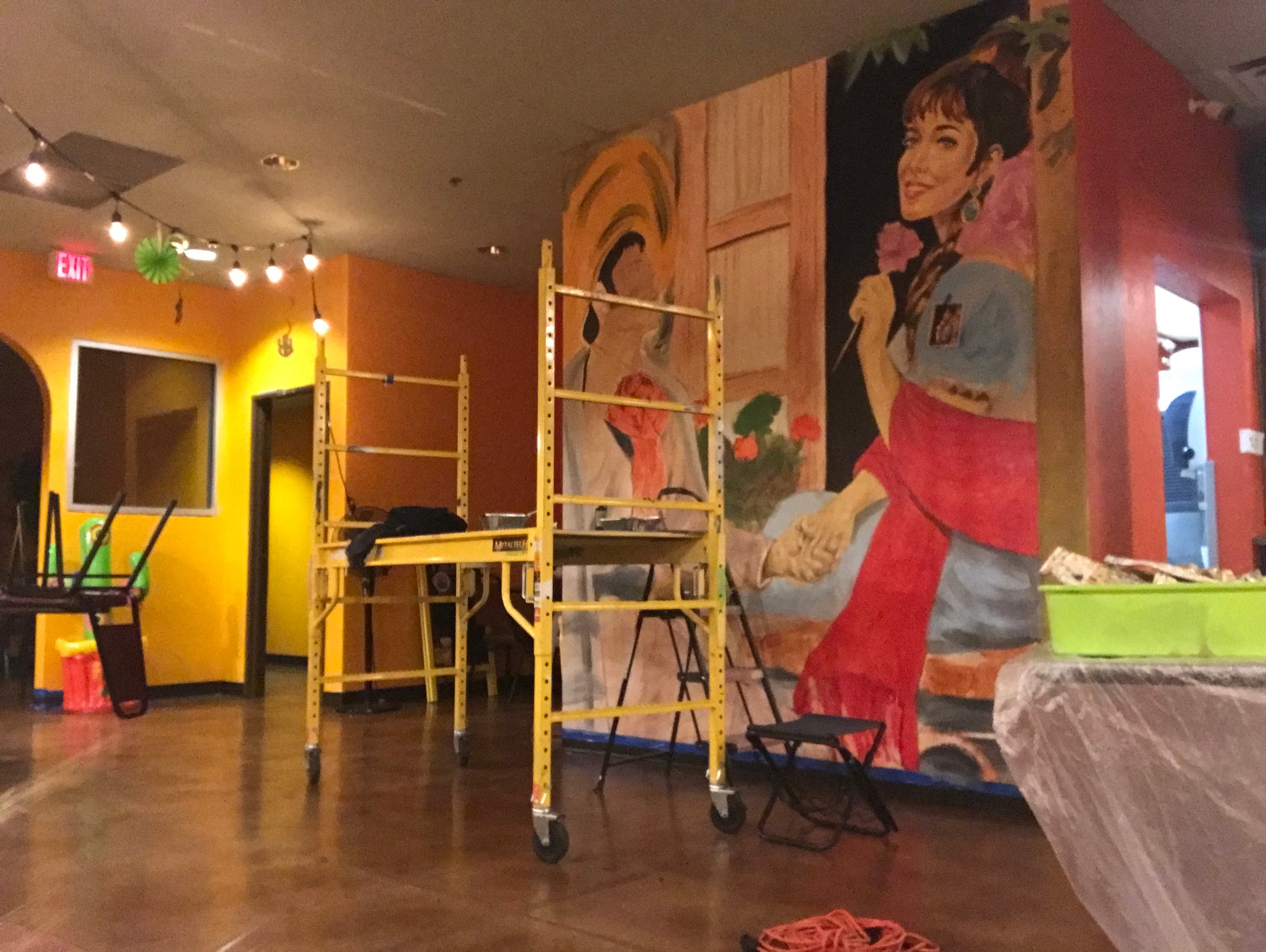 Indoor play area with colorful mural and climbing equipment