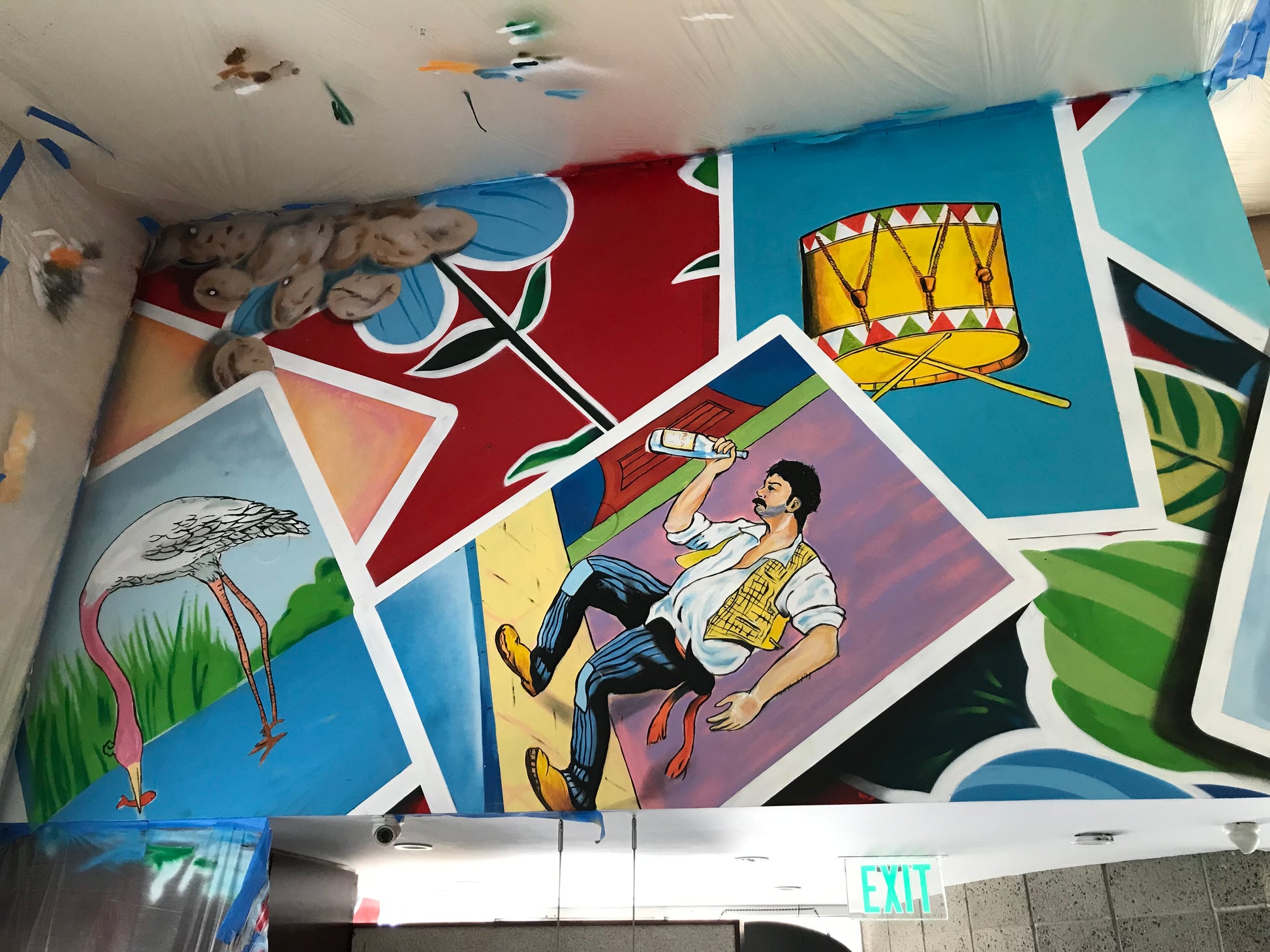 Colorful children's room with painted walls featuring various scenes and a child playing on a slide.