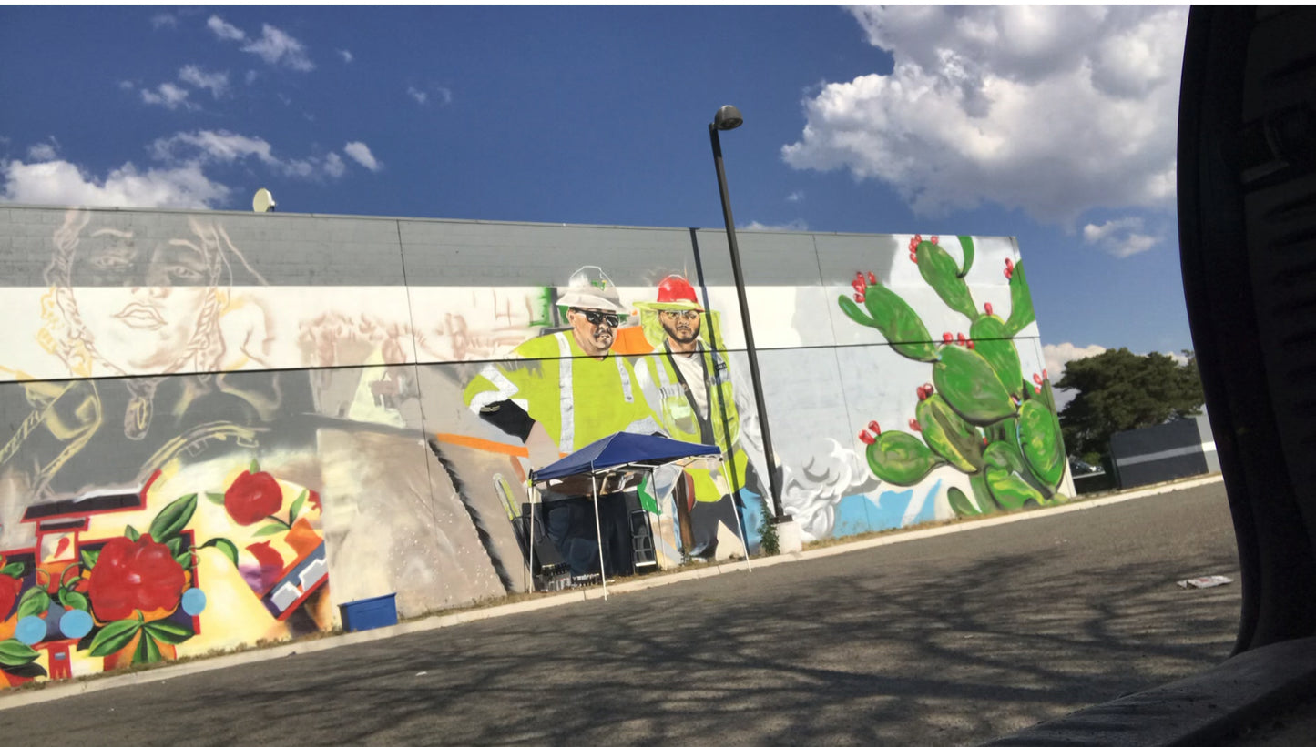 Colorful mural on a building wall with a clear blue sky.